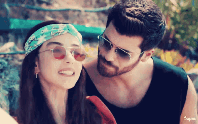 a man and a woman are posing for a picture and the woman is wearing sunglasses and a headband