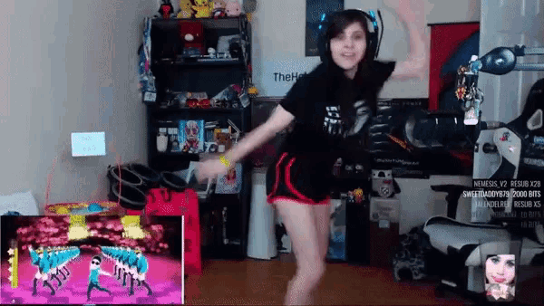 a woman is dancing in front of a tv screen that says ' the ' on it