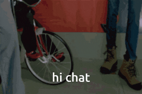 a puppet from the movie saw is sitting in a chair with a knife in his hand and says hi chat