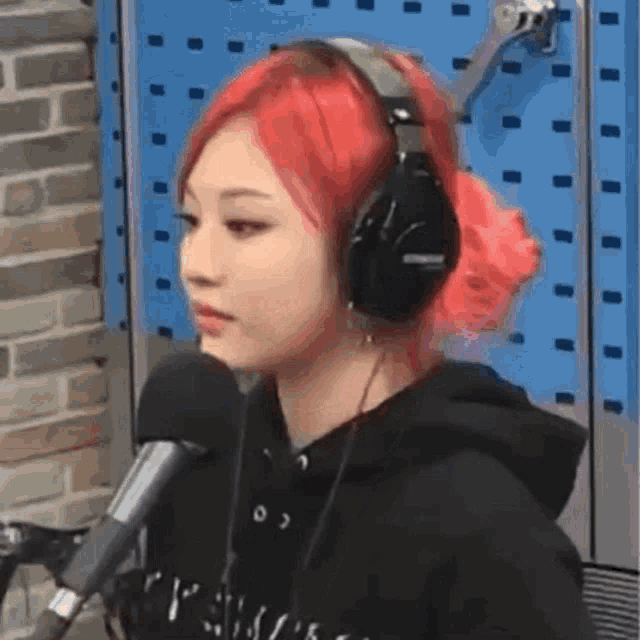 a girl with red hair is wearing headphones and a microphone .
