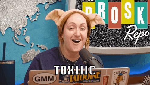 a woman wearing a pig ears headband is sitting in front of a microphone and a laptop that says gmm