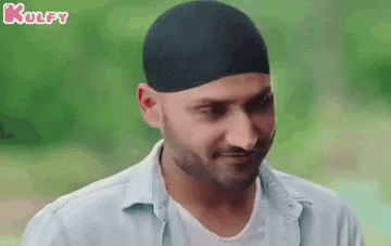 a man wearing a turban and a white shirt is smiling and looking at the camera .