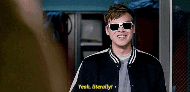a man wearing sunglasses and a jacket is smiling and saying yeah literally .