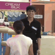 a man and a girl standing in front of a sign that says cream silk