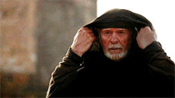 a man with a beard is wearing a black hood