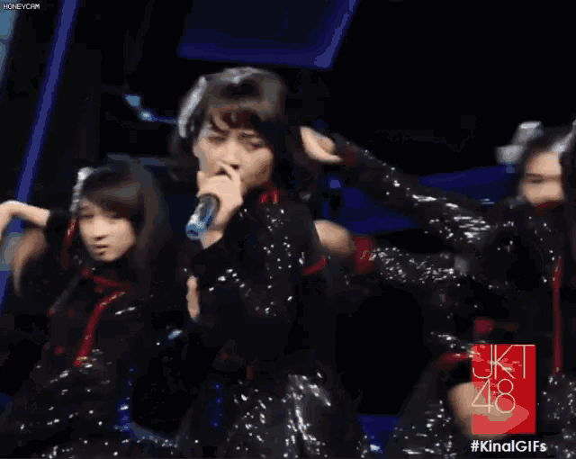 a group of girls are dancing in front of a sign that says jkt 48 on it