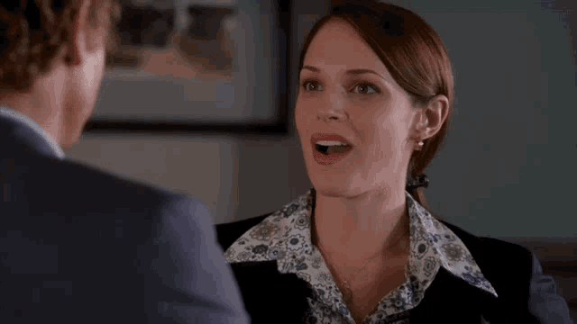 a man and a woman are looking at each other in a room