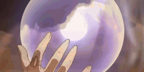 a person 's hand is reaching out towards a purple sphere .