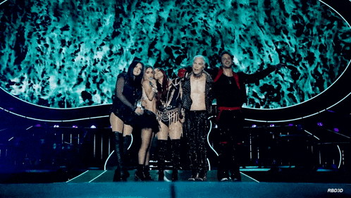 a group of people are posing for a picture on a stage with a blue background behind them that says rbd3d
