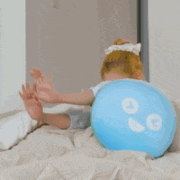 a woman is sitting on a bed next to a green pillow with the number 00 on it .