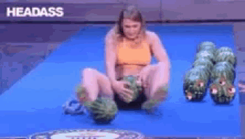 a woman is sitting on a blue mat holding watermelons and the word headass is visible in the corner