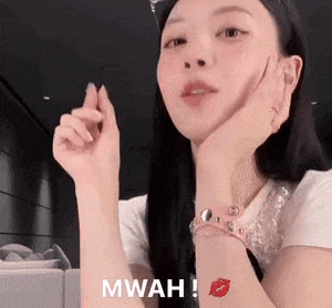 a woman is making a heart shape with her hands while wearing a watch and a bracelet .