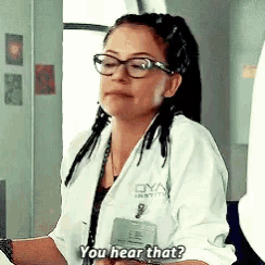 a woman wearing glasses and a lab coat is asking you hear that ?