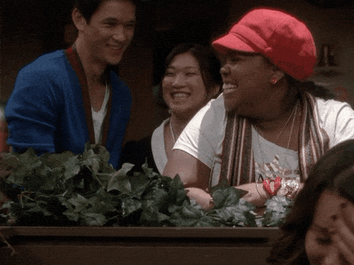 a woman wearing a red hat laughs with a man and another woman