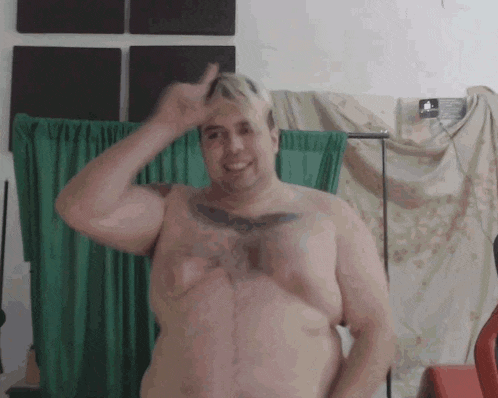 a shirtless man with a tattoo on his chest is giving the thumbs up sign