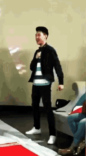 a man in a striped shirt is dancing in a room