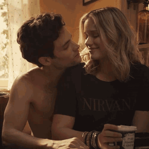 a man and a woman are hugging and the woman is wearing a shirt that says nirvana