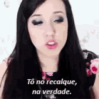 a woman with long black hair is talking in a foreign language and says to no recalque na verdade .