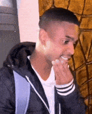 a man wearing a black jacket and a backpack is smiling