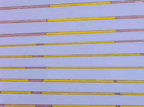 a close up of a row of yellow and pink sticks on a white surface .