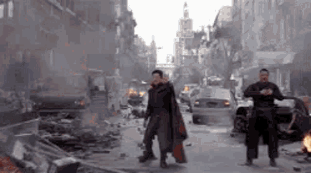 doctor strange is walking down a destroyed city street with a car in the background .