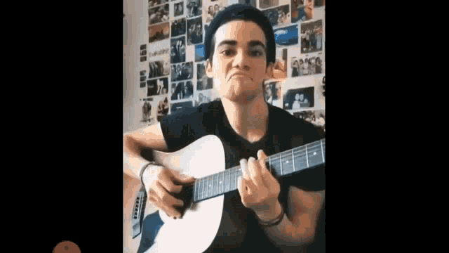 a young man is playing an acoustic guitar and making a face .