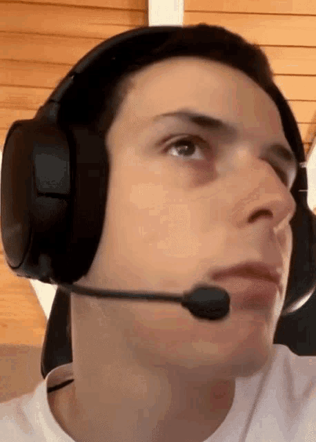 a man wearing headphones and a microphone looks to his left