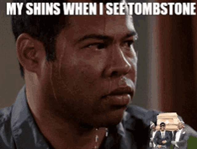 a man sweating with a picture of a coffin in the background