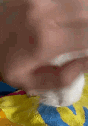 a close up of a person 's face with a yellow and blue towel .