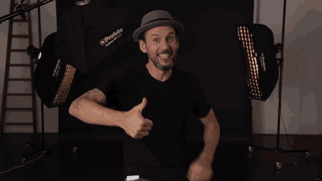a man wearing a hat is giving a thumbs up sign