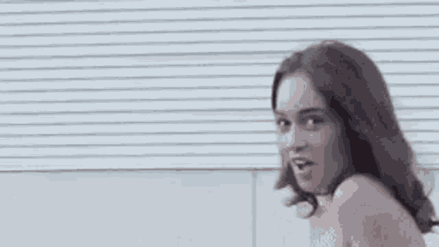 a man and a woman are standing next to each other . the woman is naked and smiling .