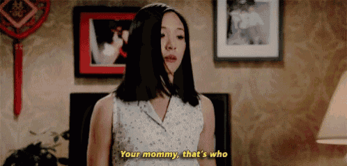 a woman is standing in a living room and talking to her mother .