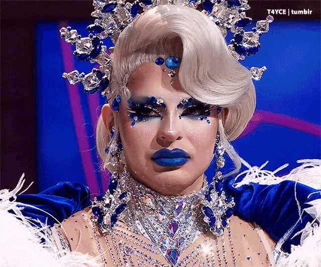 a close up of a drag queen with blue lipstick