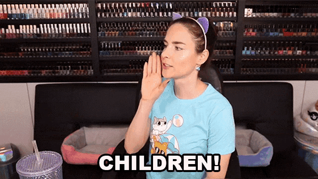 a woman wearing a blue shirt with a cat on it says children