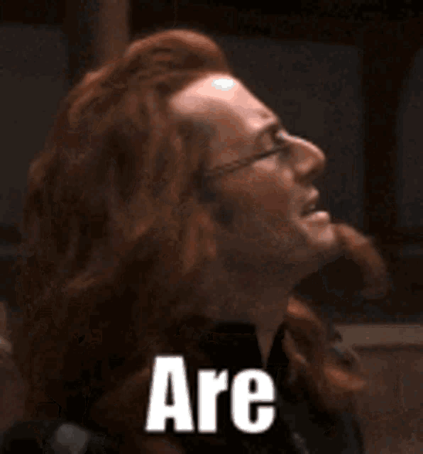 a woman with red hair and glasses says serious