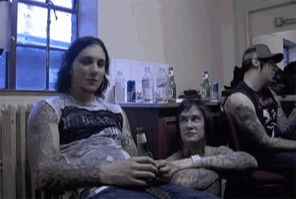 a man with a tattoo on his arm is sitting in a chair