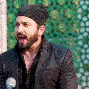 a man with a beard is wearing a black hat and a black suit .
