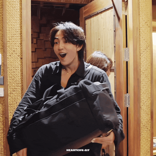 a gif of a man carrying a bag with the words heartchu.gif on the bottom right