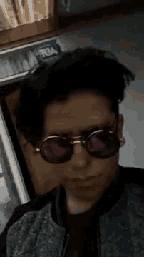 a young man wearing sunglasses is taking a selfie .