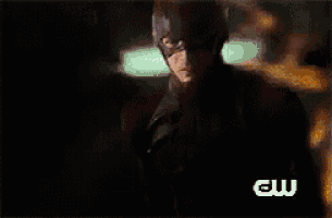 a close up of a man in a superhero costume with a cw logo on the bottom