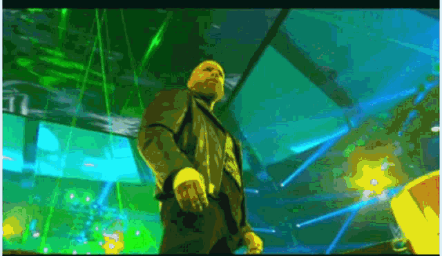 a man in a suit is standing in front of a stage with green lights behind him