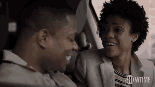a man and a woman are sitting in the back seat of a car .
