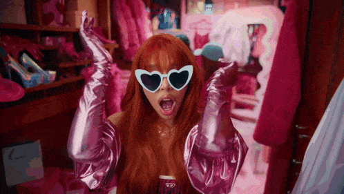 a woman wearing heart shaped sunglasses and pink gloves