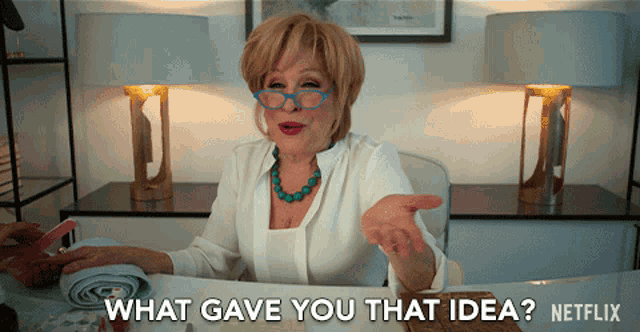 a woman sitting at a desk with the words what gave you that idea on the bottom
