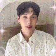 a young man wearing a white shirt is looking at the camera .