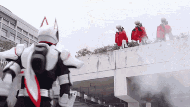 a group of people standing on top of a building with one wearing a helmet with the letter a on it