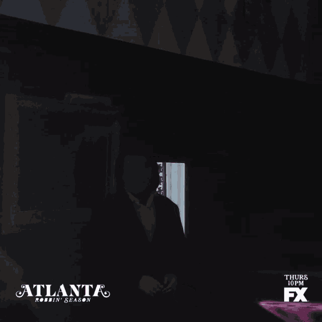 a man in a dark room with atlanta on the bottom