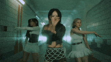 a group of women are dancing in a tunnel