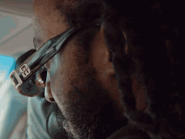 a close up of a man wearing a pair of sunglasses with the letter b on them