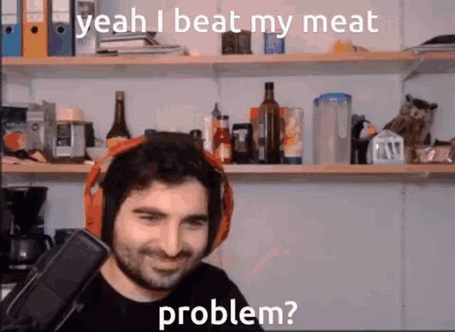 a man wearing headphones is talking into a microphone and says yeah i beat my meat problem .